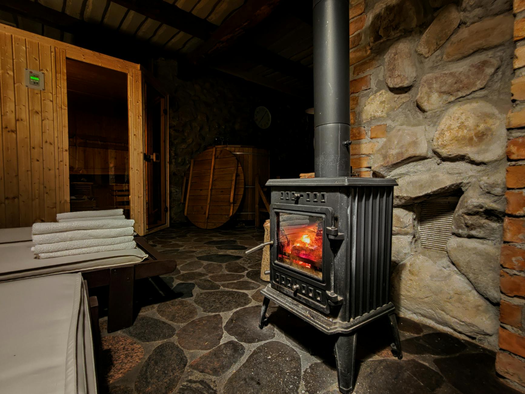Drewniana bania w Płocicznie z klasycznym piecem na drewno i kamienną ścianą