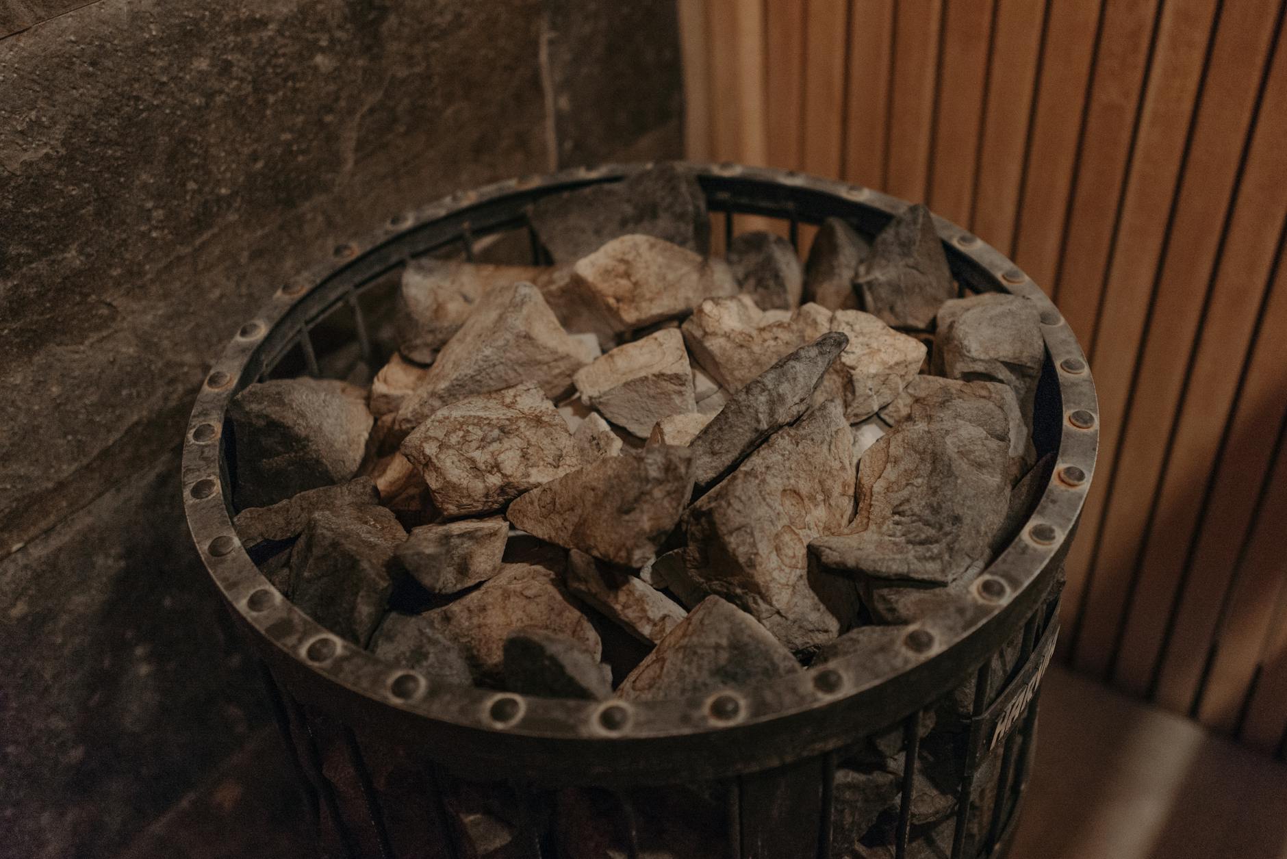 Kamienie na piecu w saunie w ciepłym, rustykalnym oświetleniu