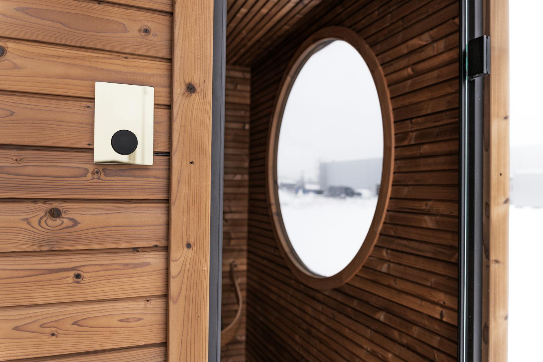 Nowoczesna drewniana bania z okrągłym oknem i panelem sterującym