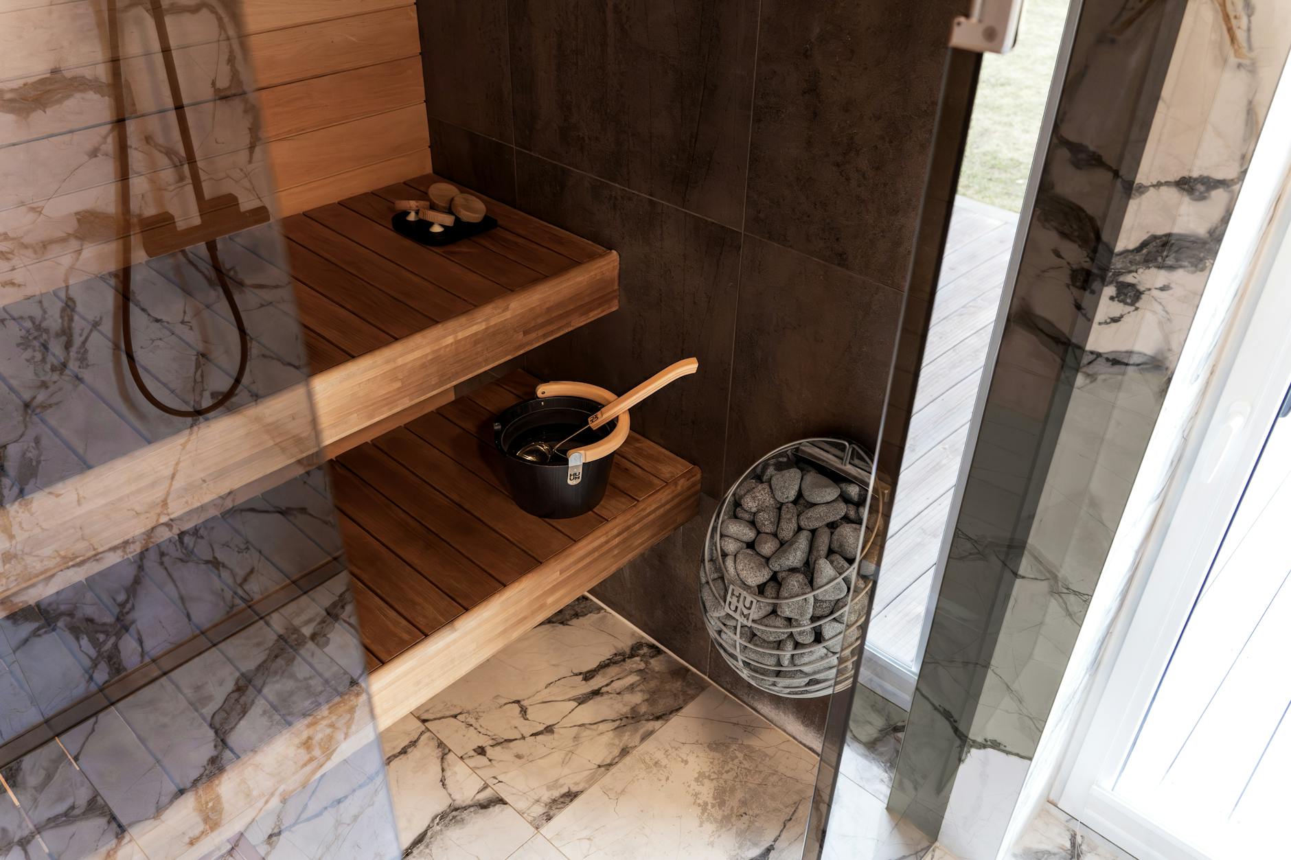 Nowoczesna drewniana sauna z wiadrem i kamieniami w stylu nordyckim