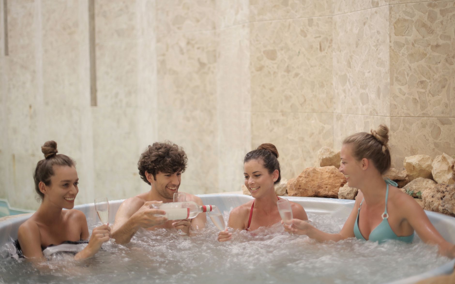 Przyjaciele relaksują się z drinkami w krytym jacuzzi