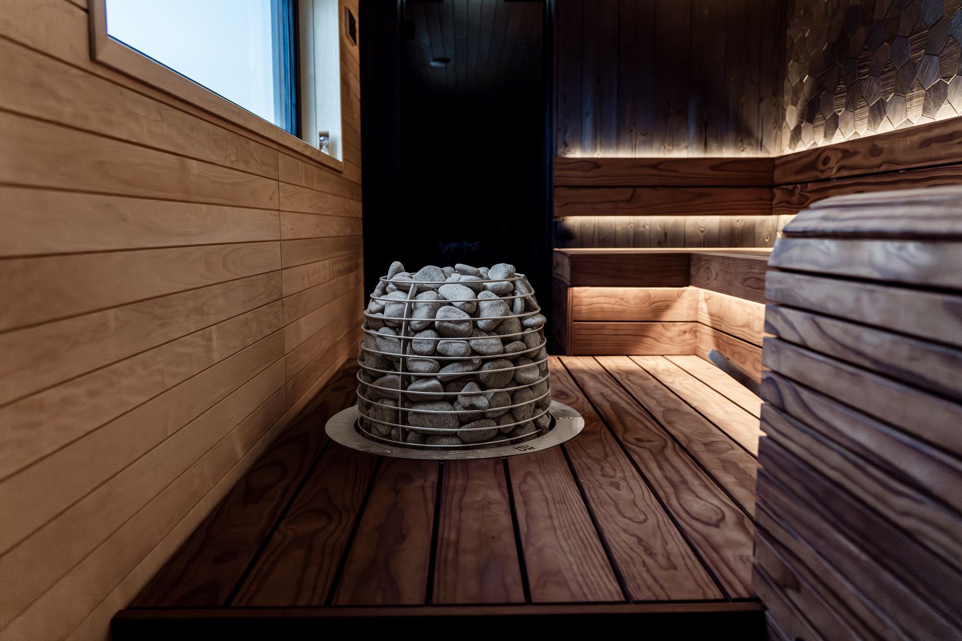 Nowoczesna sauna wewnętrzna z drewnem i kamiennym piecem elektrycznym